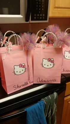 three hello kitty bags with pink bows on them sitting on top of a stovetop