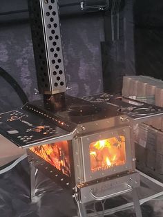 a stove that is sitting in the middle of some kind of metal structure with flames coming out of it