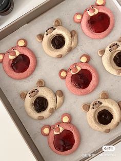 there are many cookies shaped like bears on the baking sheet with jelly in their mouths