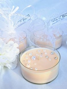 there is a glass bowl with some liquid in it next to two small vases filled with flowers