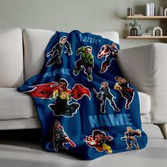 a couch with a blanket on top of it covered in cartoon character sticker sheets