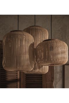 three light fixtures hanging from the ceiling in a room with wooden shutters and windows