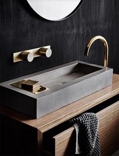 a bathroom sink sitting on top of a wooden counter next to a wall mounted mirror