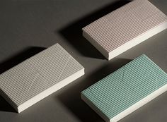 three pieces of white and blue paper sitting on top of a gray table next to each other