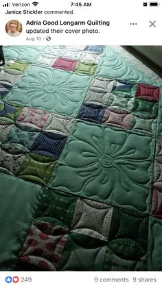 the bed is made up with green and pink quilts