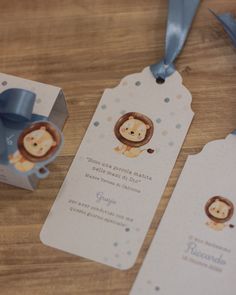 two tags with monkeys on them are sitting on a table next to a box and ribbon