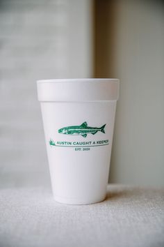 a white coffee cup sitting on top of a table