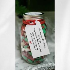 a jar filled with lots of candy sitting on top of a table next to a piece of paper