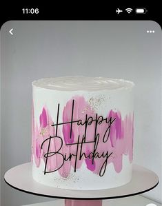 a white cake with pink icing and the words happy birthday on it's side