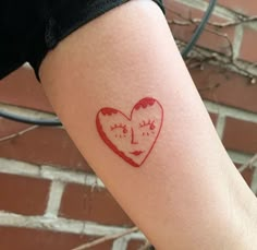 a red ink drawing of a heart with a face on it's left arm