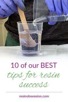 a person in purple gloves is pouring liquid into a glass with a measuring cup on it