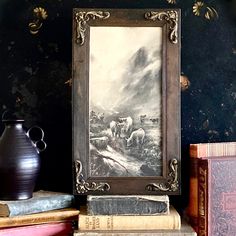 there is a painting on the shelf next to some books