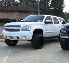 two white trucks parked in front of a store