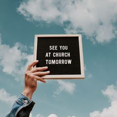 a person holding up a sign that says see you at church tomorrow in the sky