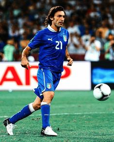 a soccer player in action on the field with a ball and fans watching from the stands