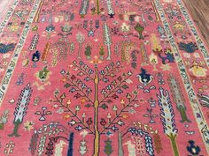 a pink rug with an intricate tree design on it