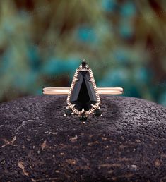 a black diamond ring sitting on top of a rock