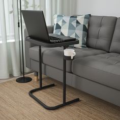 a laptop computer sitting on top of a table next to a couch