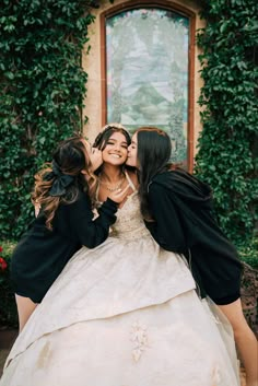 three women in wedding dresses kissing each other