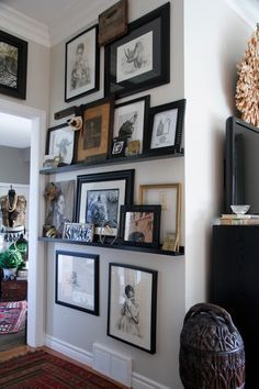 a living room with pictures on the wall and an entertainment center in the corner next to it