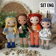 three knitted dolls standing next to each other on a table with rocks and plants