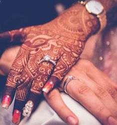 a close up of a person's hand with henna on it