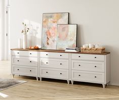 a white dresser with drawers and pictures on top