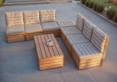 a couch and coffee table sitting on top of a cement floor next to some steps