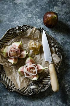 some figs are on a plate with a knife