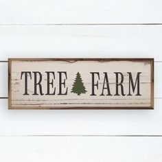 a wooden sign that says tree farm on the side of a white wood plank wall