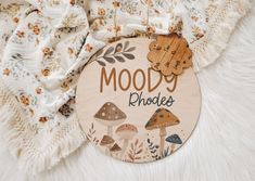 a wooden sign that says moody phoolies with mushrooms and leaves on it