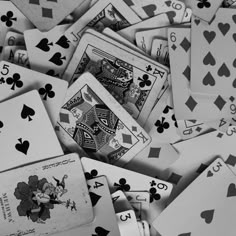 black and white image of playing cards scattered on top of each other, with one card in the middle