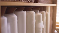 a shelf filled with lots of different types of white and brown items on top of wooden shelves