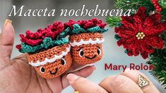 a hand holding two crocheted christmas decorations