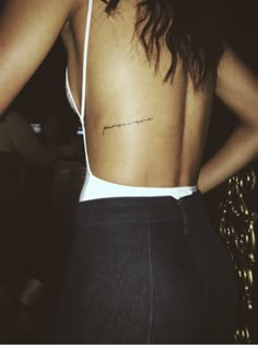 the back of a woman's upper body with writing on her left side ribcage