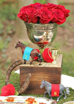 there is a small horse on top of a wooden box with flowers in the vase