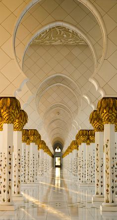 the inside of a building with columns and arches on both sides, lined with bananas