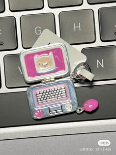 a key chain attached to a computer keyboard with a cat charm on it's side