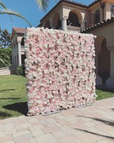 a large pink and white flowered wall in front of a house