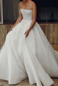 a woman in a white wedding dress posing for the camera