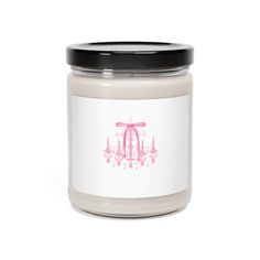 a candle that is sitting in front of a white background with pink and black accents