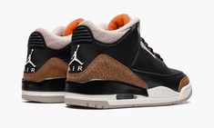 the air jordan 3 is in black, brown and white with an orange accent on the upper