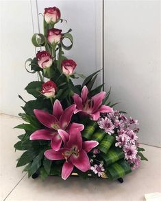 pink flowers are arranged in a basket on the floor