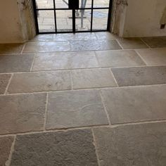 an open door leading into a room with stone floors