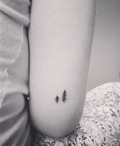 a small pine tree tattoo on the right side of the stomach, with an arrow in the middle