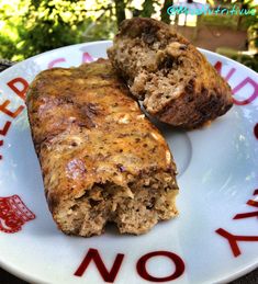 two muffins on a white plate with red writing and trees in the background