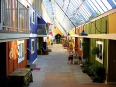 the inside of a building with several different colored walls and windows on either side of the walkway
