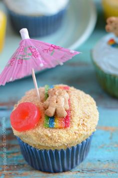 a cupcake with an umbrella on top and some other cupcakes in the background