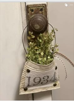 a potted plant hanging on the side of a door with a number sign attached to it