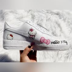 someone is holding up their white hello kitty nike air force